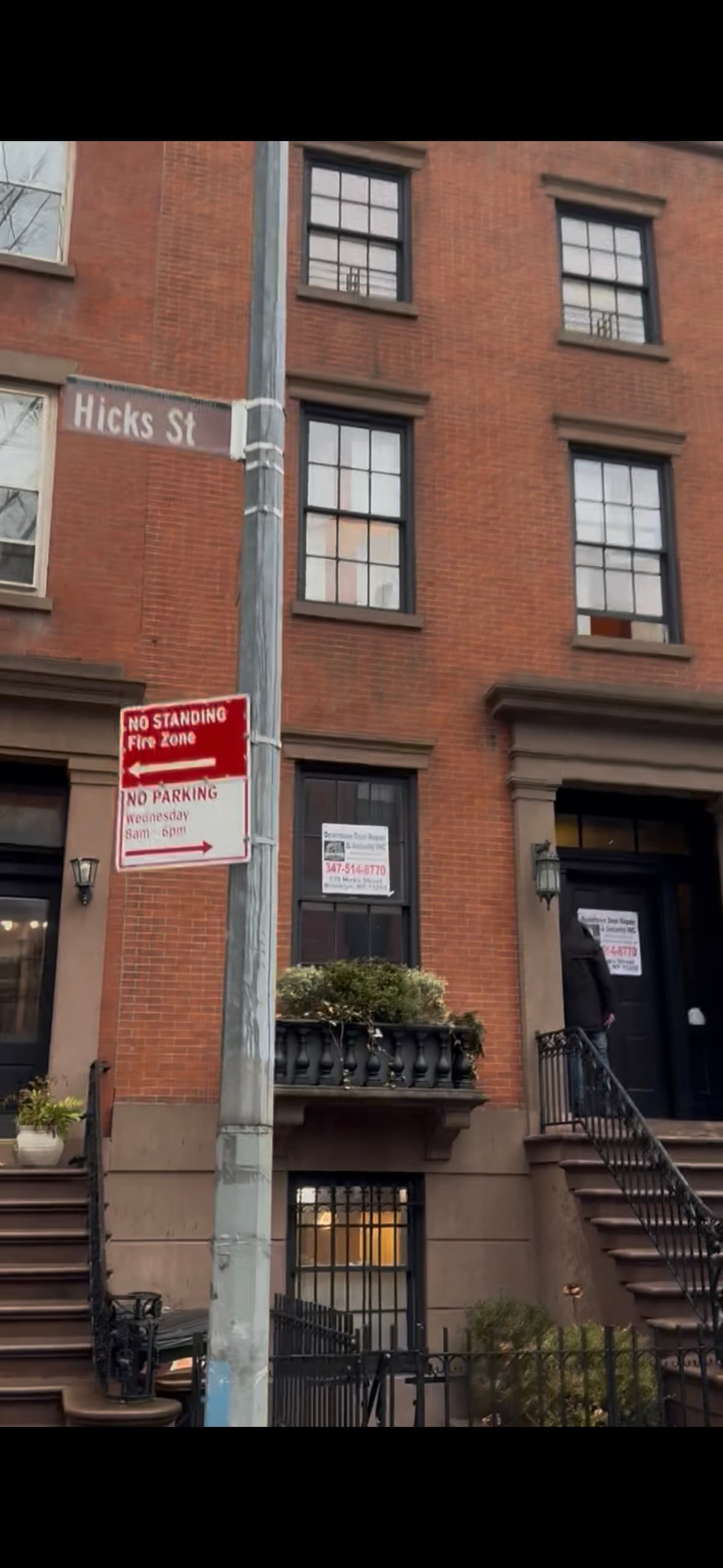 170 Hicks St from the corner — Hicks St street sign with the office's banners visible on the brownstone