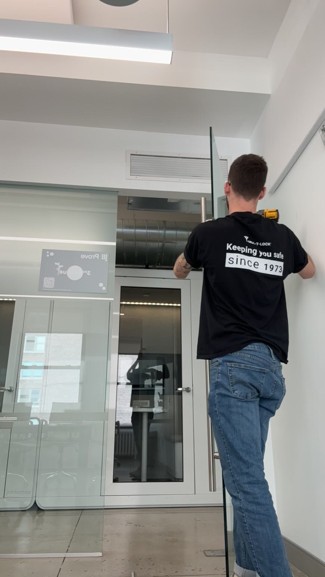 Downtown technician in a Mul-T-Lock shirt on a Brooklyn job site